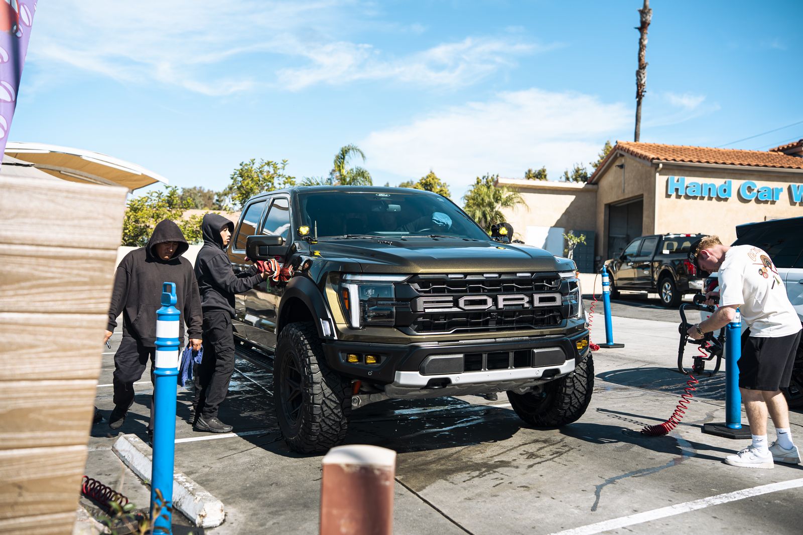 A Ford Raptor being hand-washed in front of the storefront