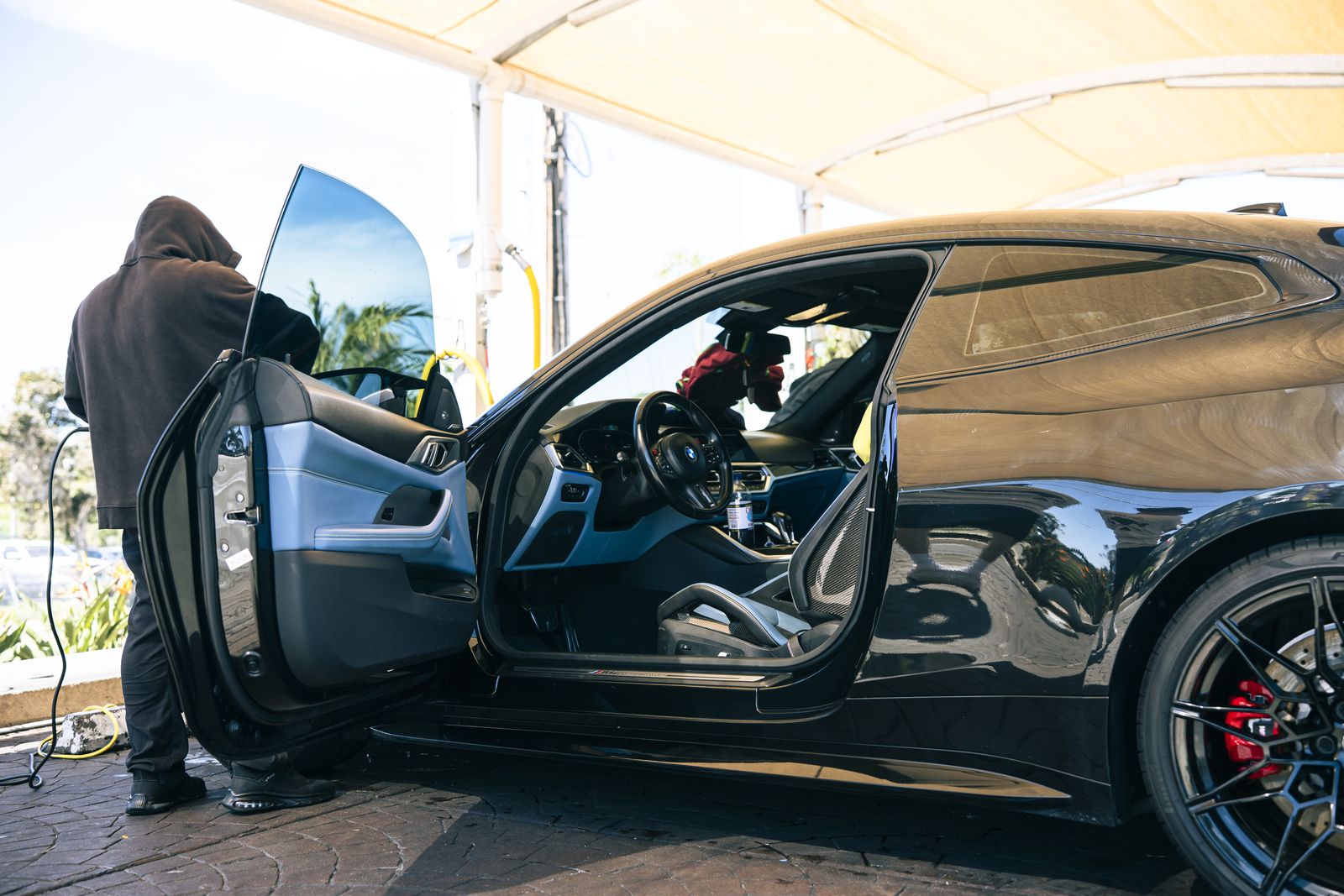 A car interior being hand-detailed with the door open